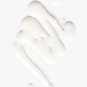 Une texture blanche de la crème solaire minérale FPS 50 non-teintée de Omy Laboratoires sur un fond blanc.